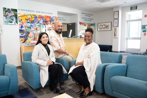 Diverse staff sit in front of multicultural center