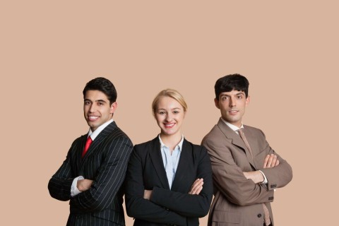 A photo of a female with two males at either side posing in business attire.