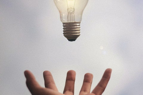 Hand throwing a light bulb