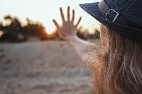 woman's hand against the backdrop of sunset