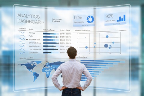 man standing in front of giant analytics dashboard