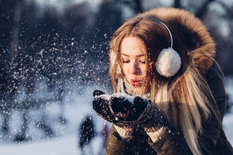 GIrl blowing snow out of her hands