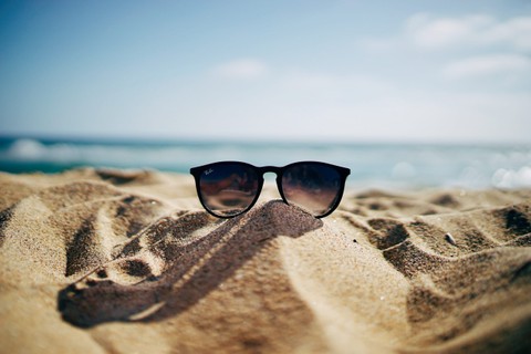sunglasses on sand at beach