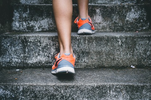 Person in running shoes ascending steps