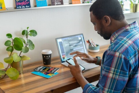 Man on computer and phone