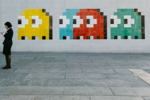 someone standing in front of wall decorated with pac man ghosts