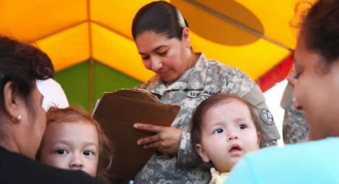 woman in military gear interviewing families