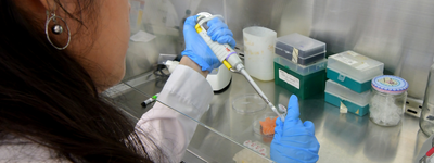 person pipetting in a lab