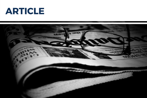 Image of a newspaper with glasses. Black and white.