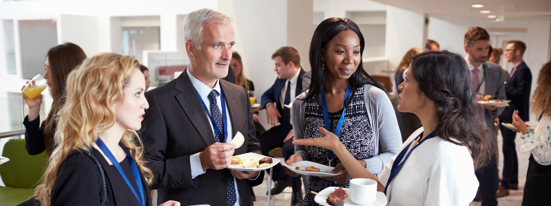 four people networking at an even wearing professional clothing