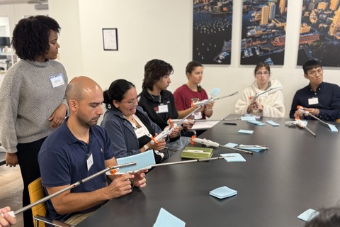 Alt text: MIT Mechanical Engineering student Francisco Jeldres, wearing blue, tests surgical staplers with classmates and Lexington Medical engineers during a hands-on site-visit activity.