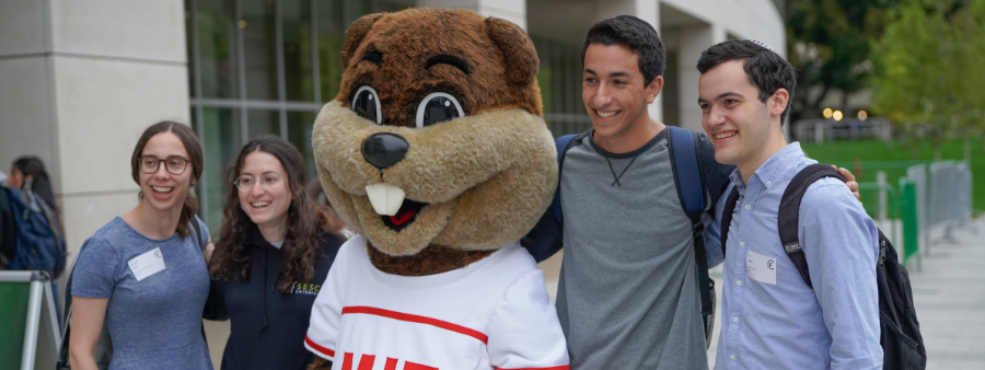 students posing with the Tim the Beaver mascot