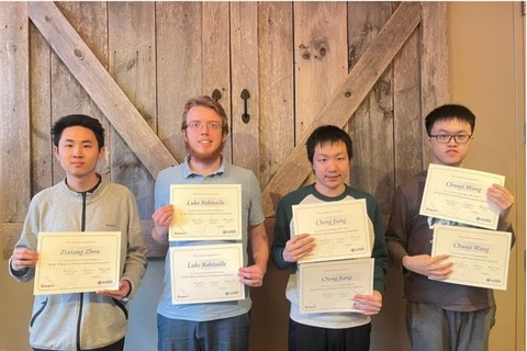 Four college males holding certificates smiling