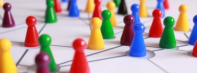 Multicolored game pieces on a board with networking lines