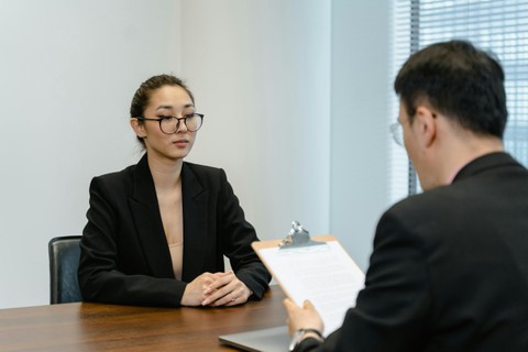 person with glasses in suit sitting at desk