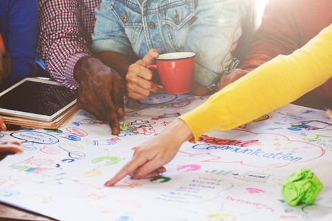 people brainstorming around a poster about social communication