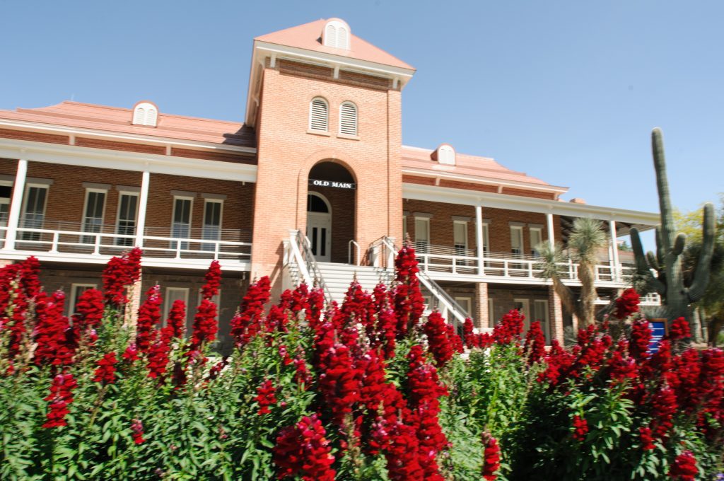 Old Main Building with red flowers in the foreground