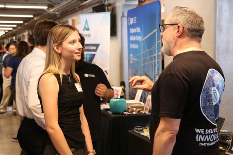 Two people are in conversation with each other at a convention.
