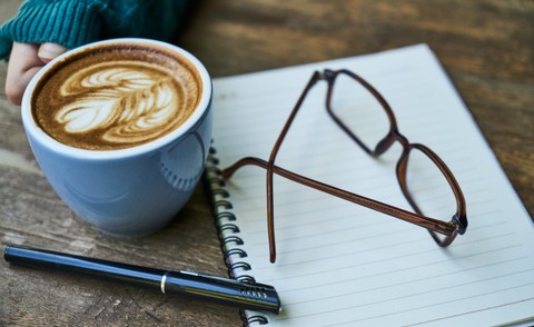 coffee and notebook sitting on a table