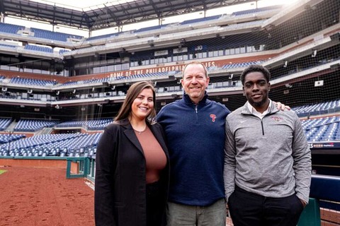 Two students with Lafayette College alumnus David Buck at Citizens Bank Park