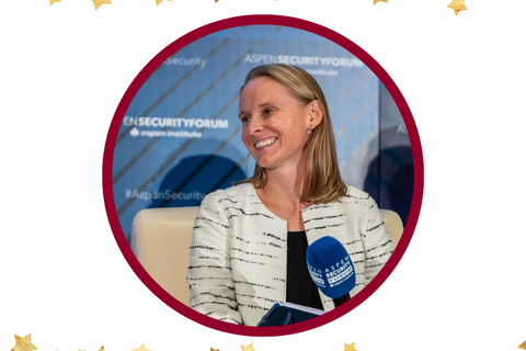 Photo of Dr. Kelly Piazza, Class of 2013, smiling and seated in front of a microphone.