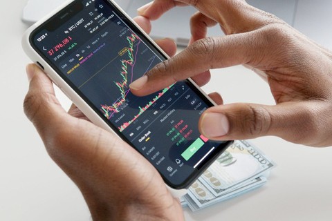Hands holding photo with stock charts appearing on the screen