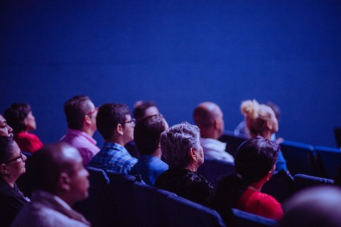People sitting in auditorium seats facing the stage
