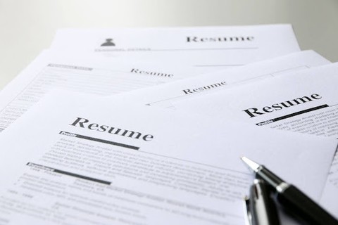 A pile of resumes and a black pen
