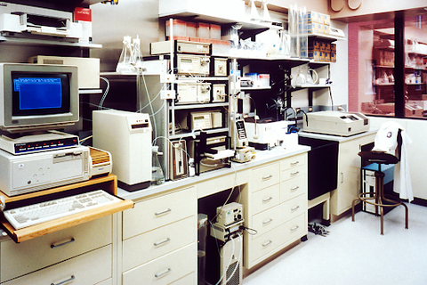 Vintage computer laboratory with technical equipment and workbenches.