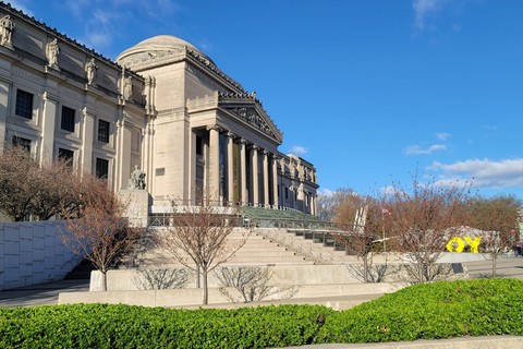 Elegant architecture of Brooklyn Museum against a clear blue sky in spring.