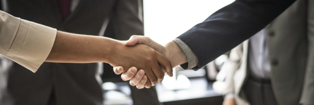 Handshake across a table during a business meeting.