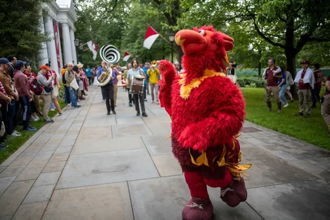 Phineas the Phoenix mascot walking down walkway in front of Parrish Hall