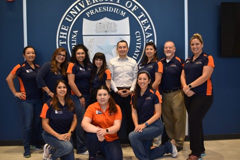 Group of people standing in front of the UTSA seal