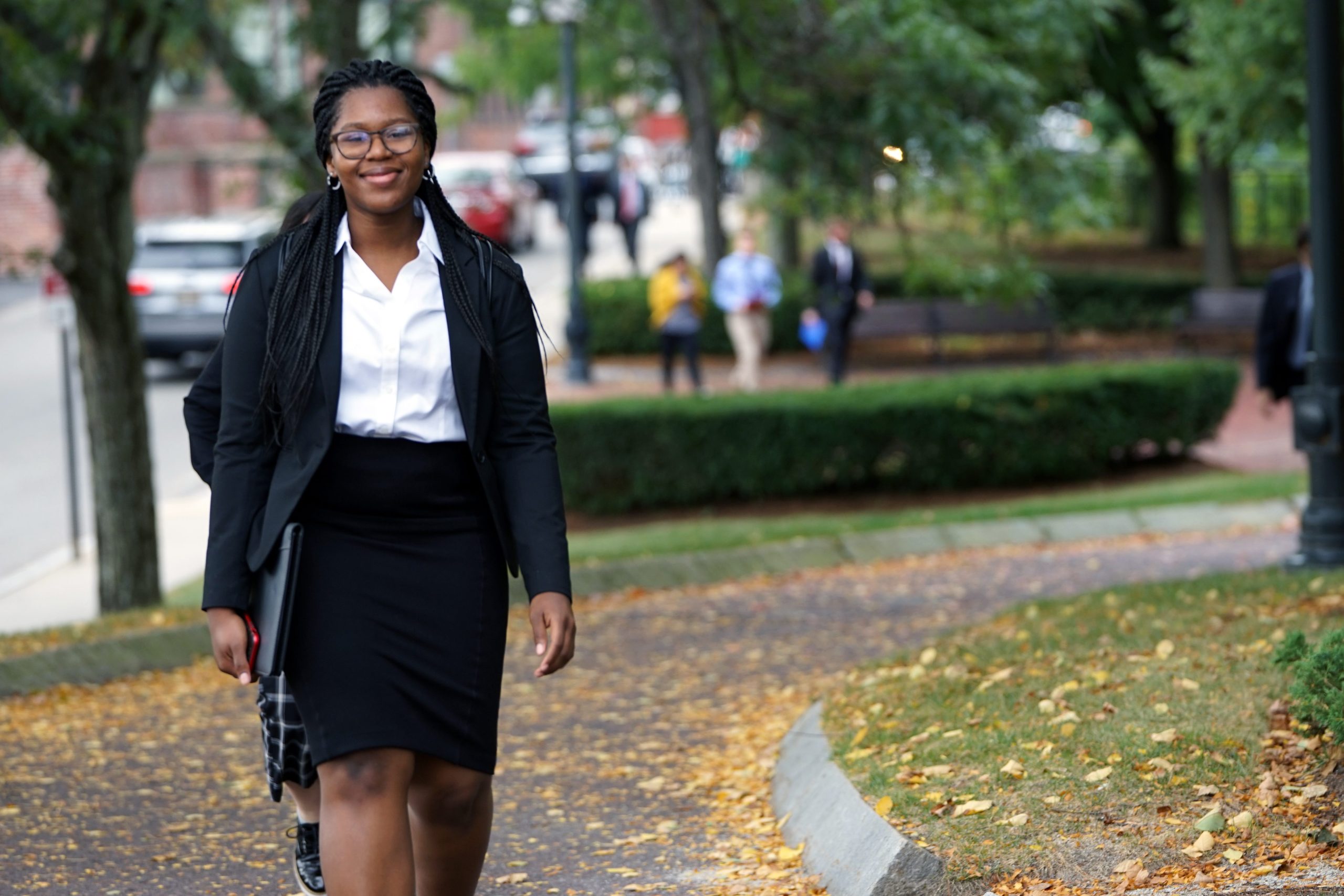A female student in business attire walking