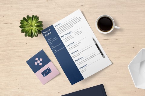 resume on a desk with coffee, plant, and business cards