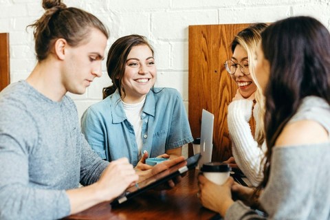 group of international students chatting together at a table.
