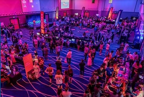 Image of people standing in a conference room with dim lighting.