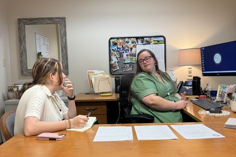 female student and female employer at computer desk talking
