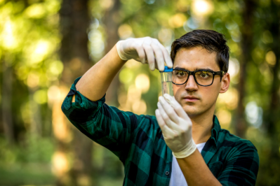 Image of a person looking at a test tube.