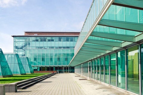 External view of the UW School of Law. A stone walkway surrounded by glass windows.