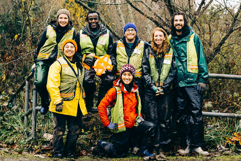 Group of 7 people in outdoor attire smiling for a photo