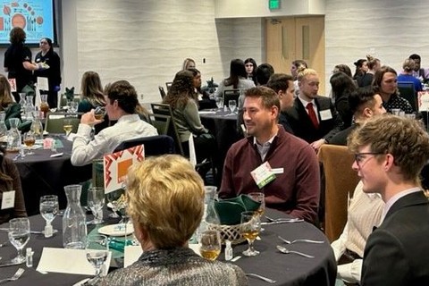 Students and employers gather over a meal in a large group.