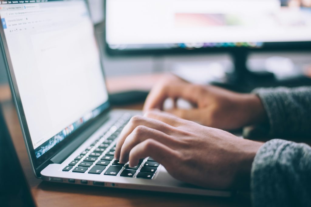 A person types on a laptop.