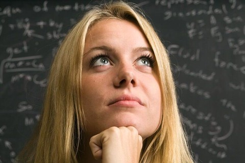 Student poses in front of chalkboard.