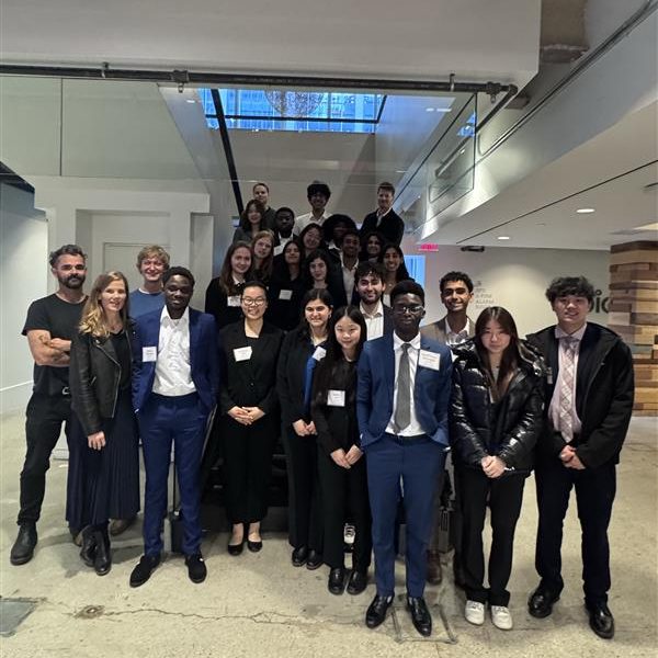 Students pose on a staircase during a company visit