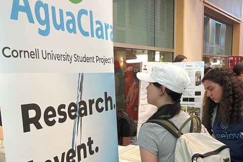 An interested student talks about Aguaclara with team reps at an interest fair.