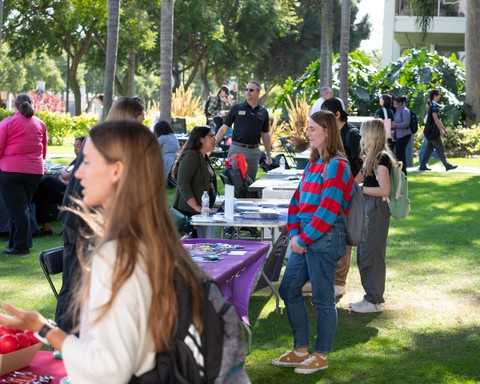 Students outside in front of a line of tables at a career fair
