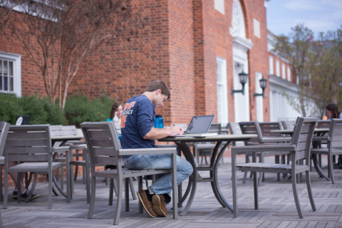 student studying on the patio outside Newcomb