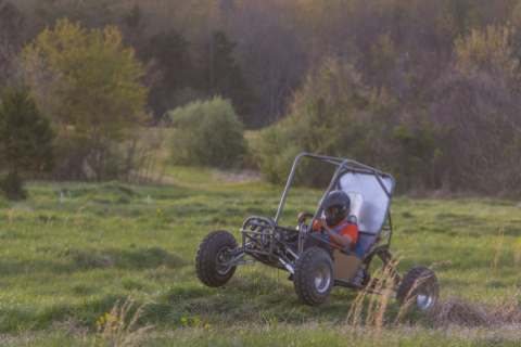 a student-built vehicle driving across the grass