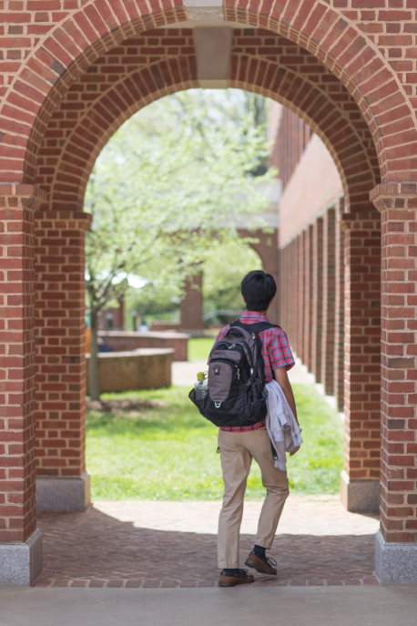 a student walking through an outdoor archway
